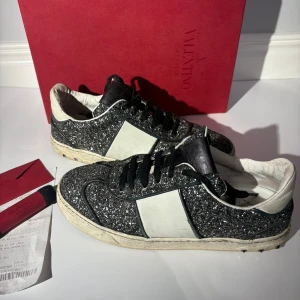 Valentino Flycrew - Väldigt fina valentino flycrew skor! Skorna är använda men ändå i ganska bra skick, sulan är lite smutsig och det saknas 2 nitar på ena skon och 3 nitar på andra. Storlek 39. Medföljer Original låda,  original snören och kort+kuvert från valentino samt kvitto! Hör av er vid frågor!