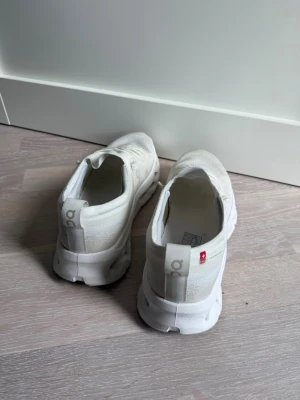 Vita On Cloud sneakers - Säljer ett par vita On Cloud sneakers med CloudTec-sula och diskret logga på sidan. Skorna har en låg profil, snörning och är tillverkade i ett mesh-liknande material som ger en sportig och clean look.