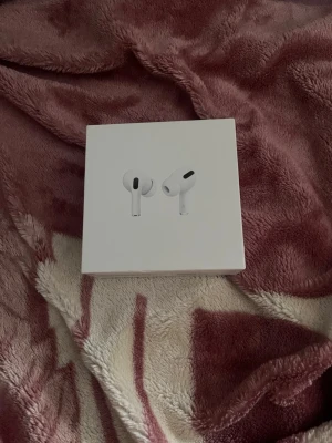 Apple AirPods Pro trådlösa hörlurar - Säljer ett par Apple AirPods Pro i vitt. Trådlösa in-ear hörlurar med stilren design och laddningsetui. Perfekta för musik, samtal och träning. Kommer i originalförpackning med klassisk Apple-look.