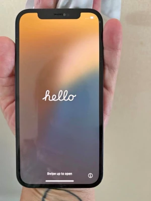 Svart iPhone med dubbla kameror - Snygg svart iPhone med stilren design och rundade hörn. Baksidan är i glas med Apple-loggan och har två kameror i hörnet. Skärmen täcker nästan hela framsidan och har en diskret notch upptill. Perfekt för dig som gillar modern teknik och enkel design.
