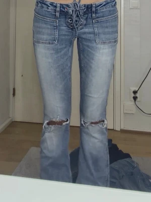 Ljusblåa Ginatricot jeans  - Säljer ett par ljusblå jeans från Gina Tricot. Använda ett få tall gånger. Man knyter den längst upp.  Inget trasigt väldigt bra skick.