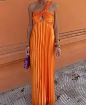Plisserad orange långklänning/ balklänning  - Snygg långklänning i plisserat tyg med stark orange färg. Klänningen har ett unikt twisted oneshoulder-band och en liten cut-out framtill. Perfekt för dig som vill sticka ut med en färgstark och trendig look. Använd 1 gång 