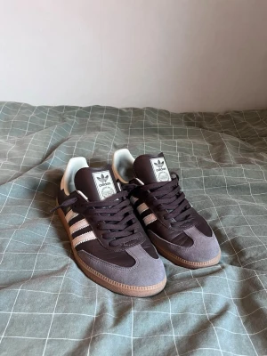 adidas Originals Samba OG - Brun/Putty Grey/Guld - Säljer nu dessa riktigt feta Adidas Samba OG eftersom att de inte passade mig. Storlek 44 och 2/3. Endast använda en gång så i princip helt nya. Jag har kvar lådan men den är helt sönderklippt eftersom farsan försökte slänga den. Kan gå ner i pris vid snabb affär! 