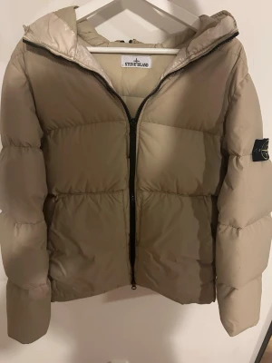 Beige vinter jacka från Stone Island - Snygg vinterjacka från storm Island nypris ligger på 12 000. Sitter som S,M,L beror lite på hur man vill att den ska sitta. Kvitto finns✅✅Liten fläck på armen men de är inget som syns vid användning. Köpt på Joel en märkesbutik i Borås. Storlek M/L