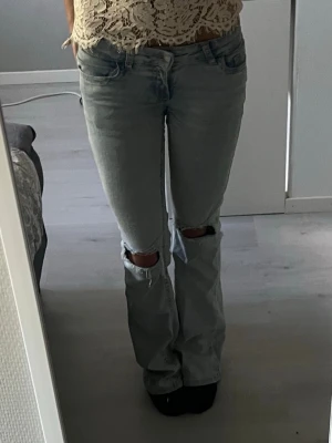 Nelly jeans - Säljer ett par ljusblå bootcut jeans med slitningar över knäna. Kommer ej till användning längre!💞