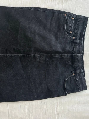 Svarta jeans från Stradivarius - Svarta jeans från Stradivarius med klassisk femficksdesign och raka ben. Jeansen har silverfärgade nitar och detaljer samt normalhög midja. Perfekta för en stilren och enkel look.
