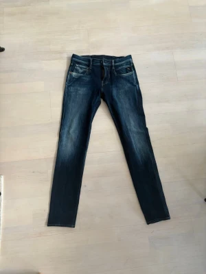Mörkblå Replay Anbass jeans - Säljer ett par riktigt snygga replay jeans. Anbass (slim fit). Skick 8/10. Storlek W27 L32. Undrar du något är det bara att höra av sig😃.