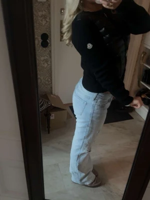 Moncler cardigan - Snygg svart dunväst med glansig finish och stickade svarta ärmar. Västen har dragkedja framtill och en tight passform som ger en modern look. Perfekt att bära över en t-shirt eller tröja för extra värme och stil.