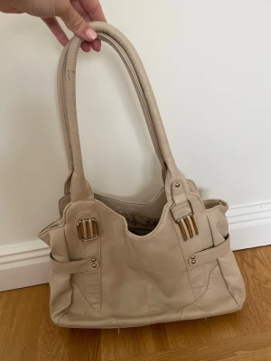Beige handväska  - Denna väska är så stilren och passar verkligen till allt😫 OBS! En silverdetalj saknar vid hantagen på väskan (se första bilden) är dock väldigt liten så märks knappt.