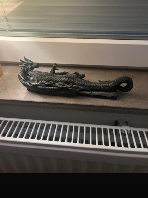 rökelsehållare drakskulptur - Säljer en rökelsehållare drakskulptur med en glaskula. Draken har tydliga fjäll, horn och en lång svans. Perfekt som dekoration på fönsterbrädan eller hyllan för dig som gillar fantasy och unika inredningsdetaljer.