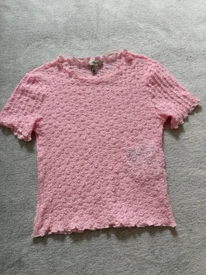 Rosa ribbad topp från AWARE - Supersöt ljusrosa topp från AWARE med ribbad struktur och korta ärmar.