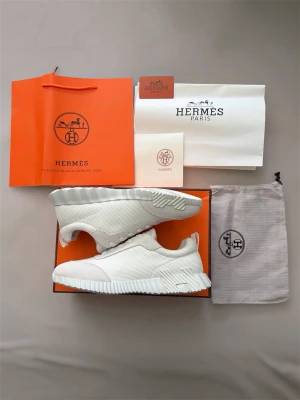 H skor vita  - Stilrena vita H-sneakers med ribbad sula och ovandel i textil och mockadetaljer. Skorna har klassisk snörning och diskreta H-detaljer. Perfekta för dig som gillar exklusiv och modern design. Pris kan diskuteras i en snabb affär.