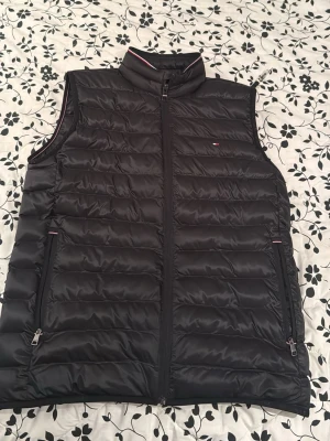 Tommy hilfiger väst - Västen är aldrig använd då den inte passar mig. Så alltså ny, nypriset på den är 2249kr. Den är köpt på Tommy hilfiger. Den passar även M då den är stor i storlek 