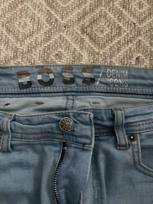 Ljusblå raka jeans från BOSS - Säljer ett par ljusblå jeans från BOSS med klassisk femficksmodell och raka ben.. Perfekta för dig som gillar en clean och stilren look. Väldigt sköna tycker jag. ( använda 1 gång) hör av er vid funderingar 