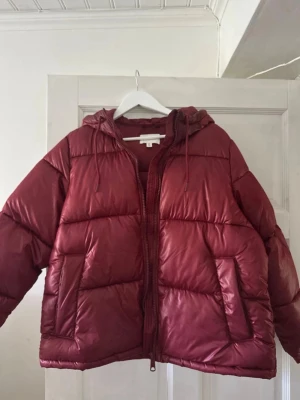 Vinröd pufferjacka från H&M - Säljer min vinröda pufferjacka som var väldigt populär för några år sedan. Fint skick förutom att det är lite fläckar som ej verkar gå bort. Misstänker att det är färgen på jackan då jag sett fler som får såhär på sina. Den mörkröda färgen som ser lite missfärgad ut märks inte alls så mycket uppe vid dragkedjan då är det mest fläcken på armarna som är mest märkbar. Jättesnygg jacka i övrigt!