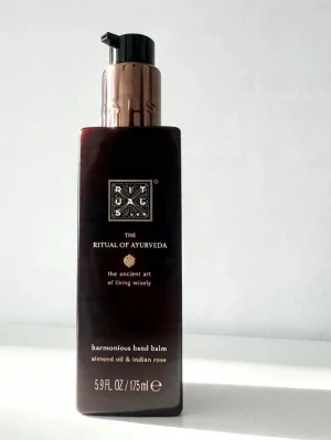 Rituals Ayurveda handbalsam 175 ml - Lyxig handbalsam från Rituals i serien The Ritual of Ayurveda. Innehåller mandelolja och indisk ros som ger näring och mjukgör händerna. Flaskan är mörkröd med gulddetaljer och har en praktisk pump. Perfekt för dig som vill ha återfuktade och väldoftande händer.