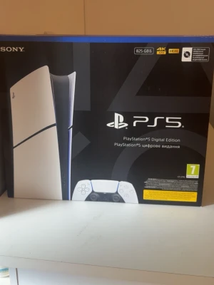 PlayStation 5 Digital Edition 825GB - PlayStation 5 Digital Edition med 825GB lagring. Konsolen har en futuristisk vit och svart design med blå detaljer och levereras med en trådlös DualSense-kontroll. Perfekt för gaming i 4K och HDR. Helt oanvänd och fortfarande i förpackning och inte öppnad. Pris kan diskuteras 