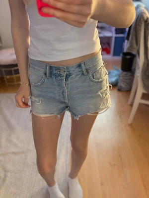 Ljusblåa shorts  - Säljer mina ljusblå shorts då jag aldrig använt dom (köpte begagnat). Dom har slitningar (ska va så) längst ner och stora bakfickor. Det finns ingen dragkedja utan det är knappar hela vägen. Skriv till mig om frågor. (Priset går alltid att diskutera)
