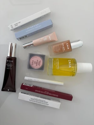 Caia NYTT STORT SET med 10 produkter! Nypris: 2700:- - Helt nytt stort paket med 10 produkter!                         * Silky Sensation Dry Oil – 529 kr * Waterproof Mascara – 275 kr * Faux Real Serum Mascara – 275 kr * Double Take Ögonpenna – 245 kr * All Eyes On Me Eyeshadow Primer – 275 kr * Wake Me Up Powder (Rhubarb) – 245 kr * Läppenna Ruby Plum – 195 kr * Perfect Pout Lip Primer – 225 kr * Dewy Drops Foundation 30N – 375 kr * Liquid Bronzer Cape Town – 345 kr
