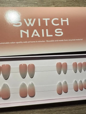 Switch Nails Almond Short press-on - Snygga press-on naglar från Switch Nails i modellen Almond Short. Naglarna har en mjuk rosa bas med vit ombre och subtilt skimmer. Tillverkade av återvunnet material och kan återanvändas. Perfekt för dig som vill ha salongskänsla hemma.