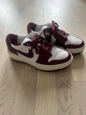 Vinröda och vita Nike Air Jordan Sneakers  - Snygga sneakers i vinrött och vitt med klassisk låg siluett. Skorna har perforerad tåbox, matchande vinröda skosnören och en vit sula med vinröda detaljer. Använda endast en gång så helt nytt skick 🙌🏽
