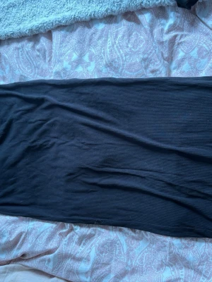 Svart ribbad långkjol från 157 - Svart långkjol från 157 i ribbat material. Kjolen har en enkel och stilren design med rak passform och resår i midjan. Perfekt att styla med en crop top eller hoodie för en chill look.