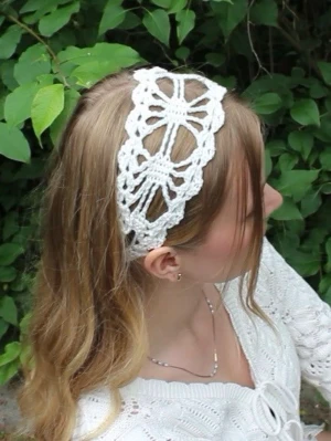 Vitt virkat hårband med spetsmönster - Unikt handgjort diadem i vitt, virkat med ett detaljerat spetsmönster som ger en bohemisk och romantisk känsla. Diademet är brett och mjukt, perfekt för att lyfta vilken outfit som helst med en vintage touch. Materialet är bomullsgarn.