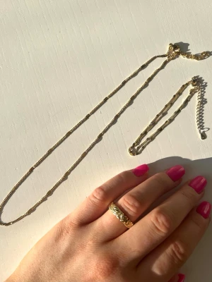 Set med halsband, armband och ring - Säljer ett set med guldfärgat halsband, armband och ring 💍 Armbandet är tvådelat! Ringens storlek är ca 17-18.  Alla smycken är knappt använda. Vet ej material tyvärr.
