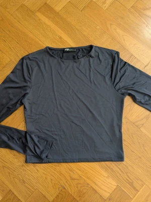 Mörkblå långärmad topp - En enkel och stilren mörkblå långärmad topp med rund hals. Tillverkad i ett mjukt och stretchigt material som känns skönt mot huden. Perfekt att matcha med jeans eller kjol för en clean look.