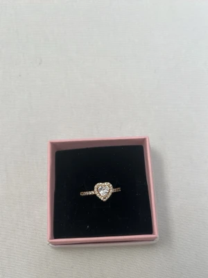 Guld Pandora ring med upphöjt hjärta - Säljer en otroligt fin guld ring med hjärta från Pandora. Har bara testats och aldrig använts. En väldigt bra present att ge i ett romantiskt eller kärleksfullt sammanhang❤️pris går att diskutera 👍