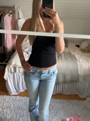 Ljusblå bootcut jeans - Säljer ett par skitsnygga jeans från gina i bootcut. De är lågmidjade med knappar där bak och väldigt sköna överlag. Älskar dessa men behövde tyvärr sälja då de började bli för korta för mig. Fråga jättegärna om mått!!😚