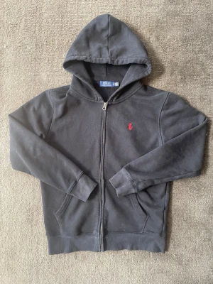 Ralph Lauren Zip - Tja, säljer denna snygga Ralph Lauren zip up i storleken M. Saknar snöret vid luvan. Hör gärna av dig vid frågor eller funderingar.