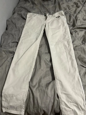 Beige jeans från J.Lindeberg - Säljer ett par beige jeans från J.Lindeberg med rak passform och klassisk femficksdesign. Jeansen har bälteshällor och är tillverkade i ett mjukt bomullstyg. Perfekta för dig som gillar stilrena och ljusa plagg. Pris kan diskuteras 