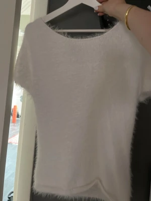 Vit fluffig topp med kort ärm - Supersöt vit topp med fluffig textur och korta ärmar. Endast testad. Jättemysig tröja från lindex