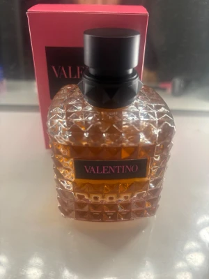 Valentino Donna Eau de Parfum 100Ml - Lyxig parfym från Valentino i en elegant, kristallmönstrad glasflaska med svart lock. Doften kommer i en rosa förpackning med svart etikett och guldtext. Flaskan har en exklusiv känsla och passar perfekt för dig som vill ha något extra.