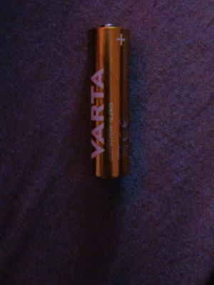 VARTA AA-batteri - Säljer ett AA-batteri från VARTA. Batteriet är cylinderformat och har en metallisk yta med tydlig märkning av pluspolen. Perfekt för olika elektroniska prylar som behöver pålitlig strömförsörjning.