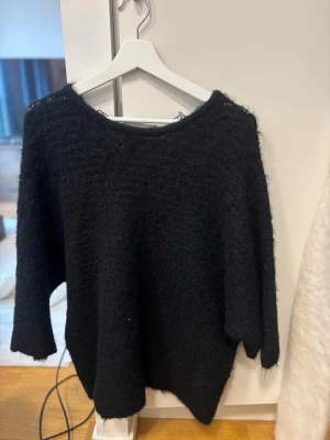 Stickad tröja  - Stickad tröja med öppen/virkat i ryggen. Mycket fint skick. Skulle vilja påstå att det är boatneck. Storlek M från Zara. Ärmarna är trekvart