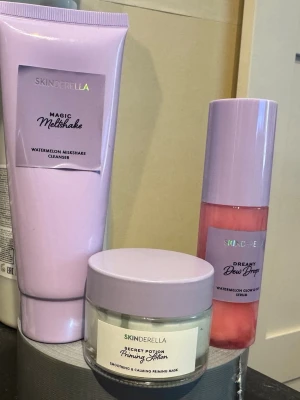 Skinderella watermelon serum och cleanser, priming lotion - DREAMY DEW DROPS Ett återfuktande serum och primer i ett som ger huden ett jämt glow och ett perfekt grepp för makeup. Den återfuktar, plumpar och ger huden en fräsch dewy finish hela dagen.  MAGIC MELTSHAKE En rengöring med tre texturer som smälter från fluffig balm till silkeslen olja och mjölkigt skum. Tar effektivt bort makeup, SPF och orenheter utan att torka ut huden – för en mjuk, lugn och strålande känsla.  SECRET POTION PRIMING LOTION En återfuktande hybrid mellan hudvård och makeup som