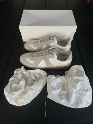 Maison Margiela GATS | Vit/Grå - Säljer ett par stilrena Maison Margiela gats i färgen vit/grå. | Storlek: 43 | Skick: 9.5/10, endast använda fåtal gånger | Kommer komplett med box och dustbags | Skickas samma dag som köp, och paketet packas noggrant för att säkerställa att varan kommer fram i bästa skick. | Pris: 3299kr, går att diskuteras vid snabb affär. | PM vid frågor om pris, eller andra frågor om varan. // William