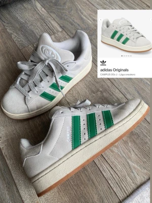 Adidas campus 00s J - i storlek 38,5 har använt några gånger men inte super mycket. Men skor blir smutsiga. Skicket kan man se bland bilderna. De har smutsfläckar. Har inte tvättat de. Men kan nog bli fina igen ifall man gör rent med mockaborste o allt. har skolådan och gröna oanvända skosnören till! inte slitna eller nåt de är bara smutsiga som man ser.Har mesty använt inomhus som man ser på undersidan.
