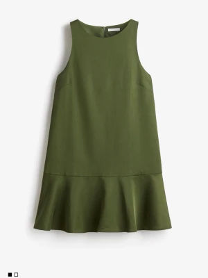 Grön kort klänning med volang - Stilren grön kort klänning i rak modell med volang nedtill. Ärmlös design och rund halsringning. Perfekt för dig som gillar enkel men trendig stil. Tillverkad i ett mjukt tyg som ger en skön känsla. Använts 1 gång. Skriv för fler bilder. 