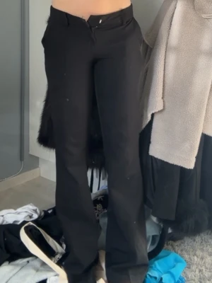 Svarta lågmidjade kostymbyxor - Säljer ett par trendiga svarta kostymbyxor från bikbok med utsvängda ben och låg midja. Använda fåtal gånger!🥰