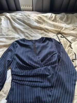 Mörkblå randig blus - Snygg mörkblå blus med vita tunna ränder samt långa ärmar och tajt midja💕Står storlek M men sitter som en S💞 Använt 1 gång!