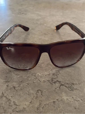 Ray-ban boyfriends! - Ray-Ban solglasögon med bruna, fyrkantiga plastbågar och tonade glas. Klassisk modell med logga på linsen och snyggt sköldpaddsmönster på skalmarna. Metallnitar framtill ger en extra detalj.ray-ban boyfriends.