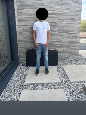 Dondup jeans  - Dondup George Skinny Fit jeans i ljusblå tvätt, storlek 33. Klassisk smal passform med snyggt tvättad look. Personen som bär byxorna är 189 cm lång och väger ca 76 kg. Jeans i fint begagnat skick med normala spår av användning. Nypris ca 3 400 kr.