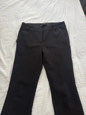 Svarta kostymbyxor från BikBok - Snygga svarta kostymbyxor med låg midja  från BikBok i storlek 34. Byxorna är bootcut och de passar mig bra i längden och jag är 162cm. 