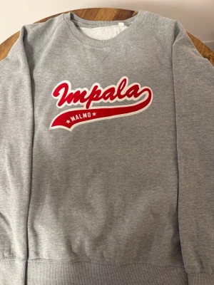 Impala Malmö Sweatshirt XL – Vintage - Säljer en klassisk Impala Malmö sweatshirt i grått. Storlek: XL Äldre modell i mycket fint skick. Snyggt vintageplagg från ett ikoniskt Malmö-märke.