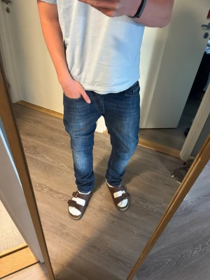 Mörkblå jeans från Acne Studios - Snygga mörkblå jeans från Acne Studios. Jeansen har en lätt tvättad look. Perfekta för en avslappnad och trendig stil!                            Jeansen är i nyskick✅.                                                                 Storlek 32/32 Herr.  Mått📏:                                          Midja:41,5cm.   Fotvidd:18cm.   Ytterbenslängd:107cm.   Innerbenslängd:81cm
