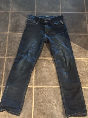 Mörkblå jeans från Replay - Ny pris: 1000 kr: vårt pris 400 kr! Snygga mörkblå jeans från Replay med klassisk femficksdesign och kontrastsömmar. Jeansen har smal passform och dragkedja fram. Perfekta för en trendig och avslappnad look.