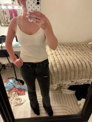 Vit linnetopp med spetsdetalj - Säljer en enkel och stilren vit linnetopp med smala axelband och spetsdetalj vid urringningen. Toppen har en figurnära passform och är perfekt att matcha med jeans eller kjol. Materialet känns mjukt och bekvämt mot huden. Jag har gjort hålet själv 